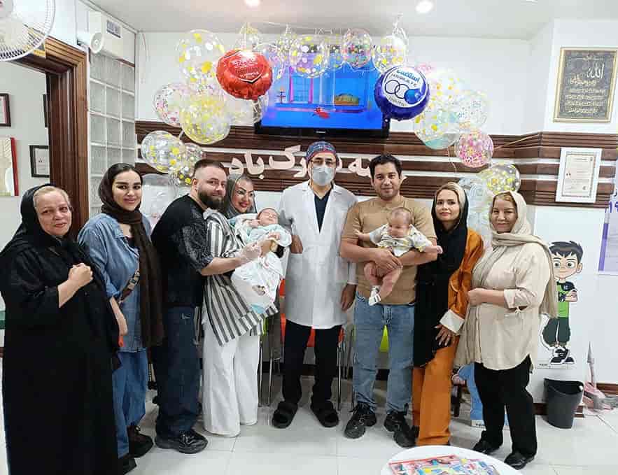 نوزاد شادمان در آغوش پزشک پس از ویزیت در کلینیک ختنه استاد دکتر بلندی